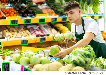 Portrait of a guy seller working in a vegetable store Portrait of a guy seller working in a vegetable store 97898121