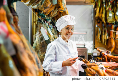 Female seller of butcher store preparing jamon of lamb for sale 97898143