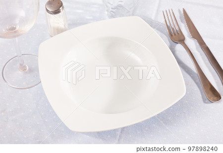 Table setting before festive banquet - plate, knife and fork Table setting before festive banquet - plate, knife and fork 97898240