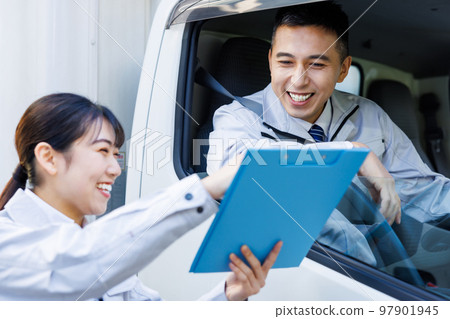 Delivery staff having a meeting with a truck driver 97901945