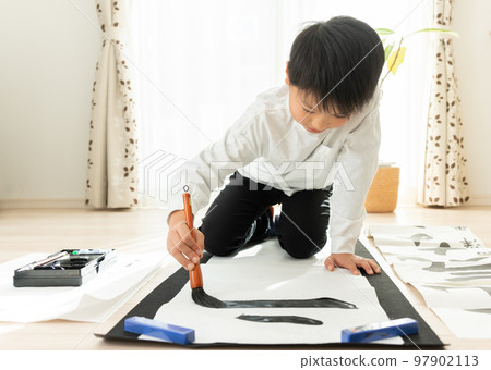 Japanese elementary school boy writing kakizome 97902113