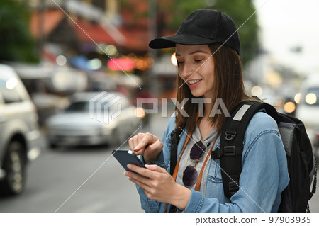 Smiling young hipster female traveler searching direction on smart phone. Life, people, travel and technology concept Smiling young hipster female traveler searching direction on smart phone. Life, people, travel and technology concept 97903935