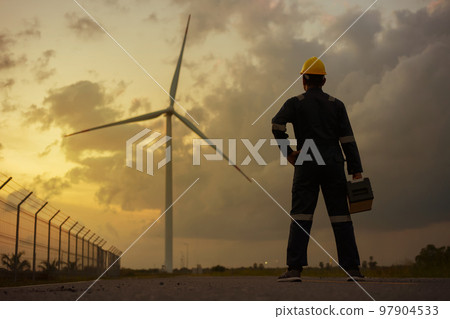 Man inspection engineers preparing and progress check of a wind turbine with safety in wind farm in sunset. Man inspection engineers preparing and progress check of a wind turbine with safety in wind farm in sunset. 97904533