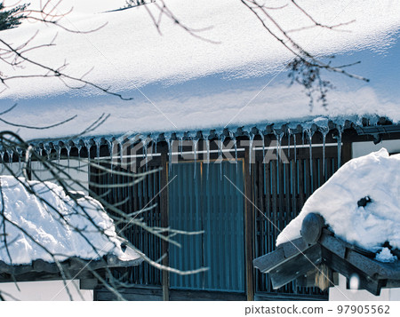 屋頂上有雪的老房子和冰柱 97905562