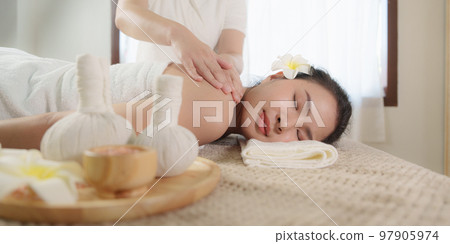Young woman doing relaxing massage in spa salon. Female being massaged by a masseur. Spa and medicine concept 97905974