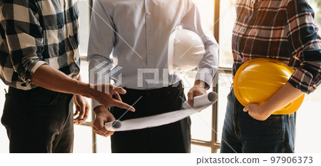 Engineer people meeting working in modern office for discussing, engineering .Hands of Engineer working on blueprint Construction concept. 97906373