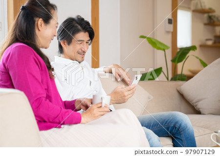 Men and women having a conversation in the living room 97907129