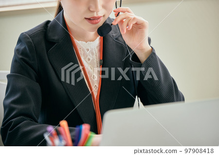 Young woman answering the phone in the office 97908418
