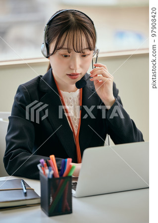 Young woman answering the phone in the office 97908420