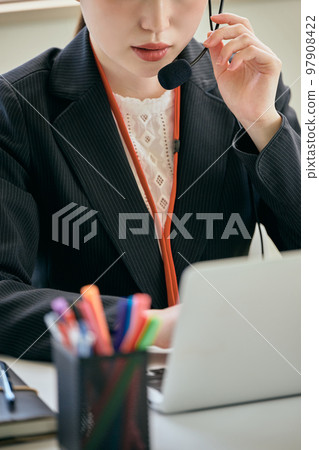 Young woman answering the phone in the office 97908422