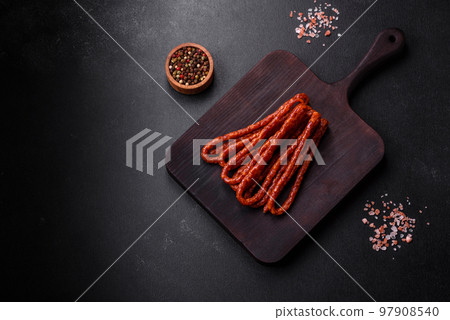 Delicious thin smoked meat sausages with spices and herbs 97908540