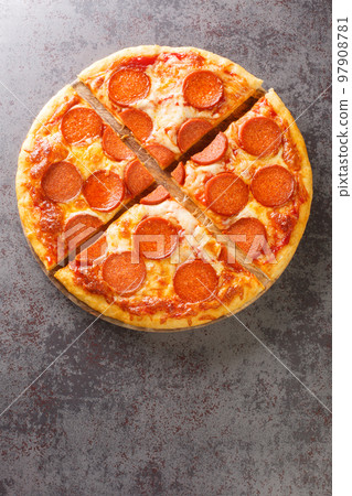 Hot homemade Pepperoni pizza ready to eat close-up on a wooden board. Vertical top view 97908781