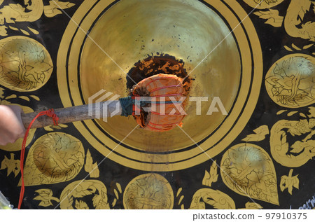 hold wooden hammer to hit big circle bell in Buddhism temple, ancient Thai cultural beliefs hold wooden hammer to hit big circle bell in Buddhism temple, ancient Thai cultural beliefs 97910375