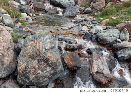 Waters of transparent alpine stream have been rushing down for centuries Waters of transparent alpine stream have been rushing down for centuries 97910749