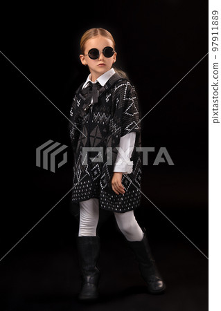 Little girl in a black glasses, dark poncho, black boots and a clutch in her hand 97911889