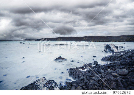 Volcanic lake surrounded by lava rocks Volcanic lake surrounded by lava rocks 97912672