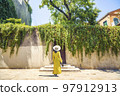 Woman in yellow dress waiting as a guest Woman in yellow dress waiting as a guest 97912913