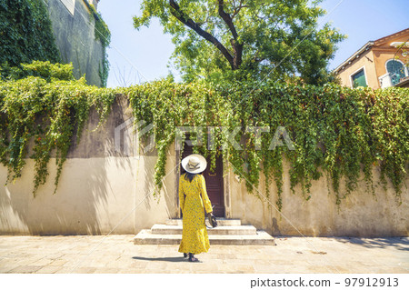 Woman in yellow dress waiting as a guest Woman in yellow dress waiting as a guest 97912913