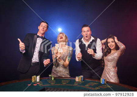 Group of a stylish rich friends are playing poker at casino. Group of a stylish rich friends are playing poker at casino. 97912928