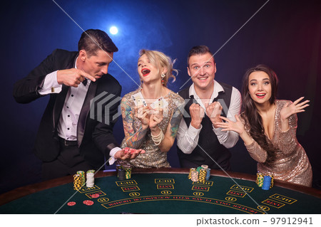 Group of a stylish rich friends are playing poker at casino. Group of a stylish rich friends are playing poker at casino. 97912941