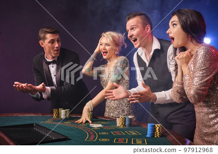 Group of a stylish rich friends are playing poker at casino. Group of a stylish rich friends are playing poker at casino. 97912968