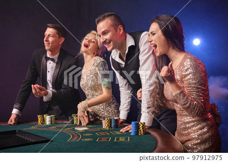 Group of a stylish rich friends are playing poker at casino. Group of a stylish rich friends are playing poker at casino. 97912975