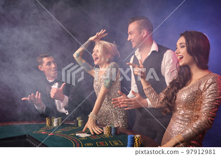Group of a stylish rich friends are playing poker at casino. Group of a stylish rich friends are playing poker at casino. 97912981