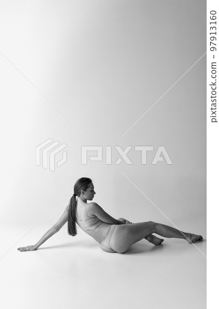 Black and white photography. Back view photo of tender, slim woman posing in underwear. Body aesthetics 97913160