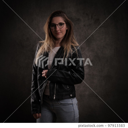 Close-up of a young attractive woman against dark grey background Close-up of a young attractive woman against dark grey background 97913383