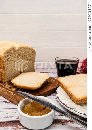 Overhead view of a homemade bread, slices and some sweet in a pot on a rustic tableNormal view of a homemade bread made with a bread machine, slices on a plate and some sweet in a pot on a table Overhead view of a homemade bread, slices and some sweet in a pot on a rustic tableNormal view of a homemade bread made with a bread machine, slices on a plate and some sweet in a pot on a table 97913597