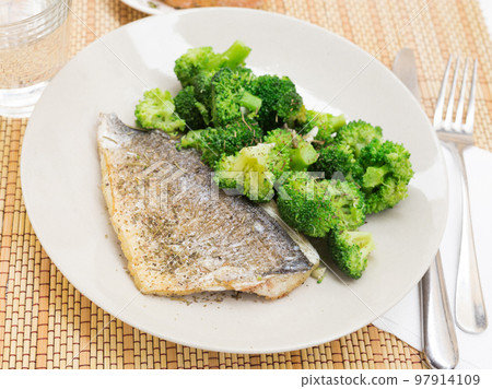 dish of fried dorado fish fillet with boiled broccoli 97914109