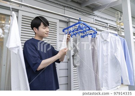一個年輕人掛上洗衣店 一個年輕人掛上洗衣店 97914335