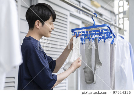 一個年輕人掛上洗衣店 一個年輕人掛上洗衣店 97914336