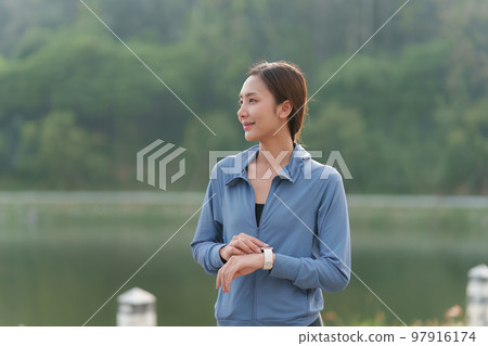 Healthy Asian woman is jogging outdoor. Fitness girl running. Female exercising at outdoor park Healthy Asian woman is jogging outdoor. Fitness girl running. Female exercising at outdoor park 97916174