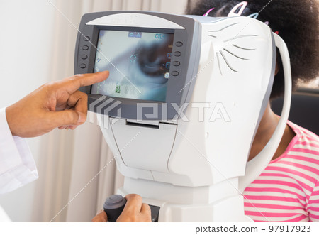 The ophthalmologist is checking the eye vision of the attractive young girl in a modern clinic. diagnostic ophthalmology equipment 97917923