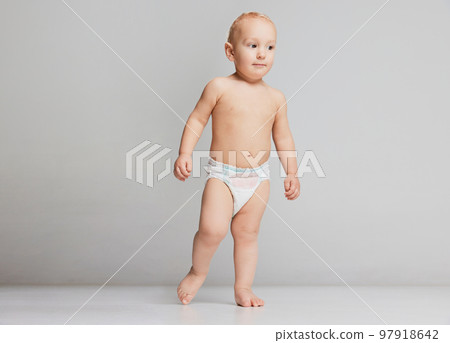Full-length footage of cute toddler boy, baby in diaper isolated over grey studio background. Concept of happy childhood, motherhood, life, birth. Full-length footage of cute toddler boy, baby in diaper isolated over grey studio background. Concept of happy childhood, motherhood, life, birth. 97918642