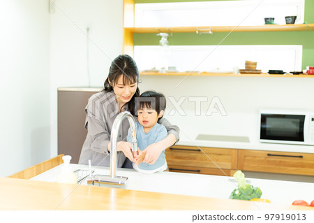 A mother helping a 2-year-old boy to wash his hands A mother helping a 2-year-old boy to wash his hands 97919013