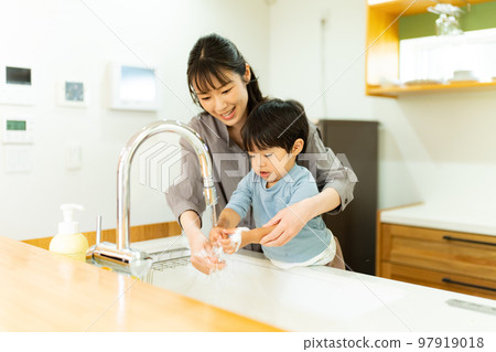 A mother helping a 2-year-old boy to wash his hands A mother helping a 2-year-old boy to wash his hands 97919018
