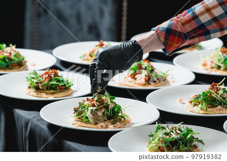 The chef at the restaurant making Spicy Shrimp Tacos with Coleslaw and Salsa 97919382