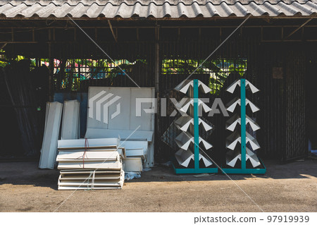Empty old metal book or magazines shelves. Old bookshelves that are no longer in use due to the end of the new generations reading era have been abandoned and no longer matter in front of the old shed 97919939