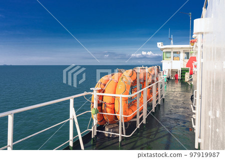 Orange inflatable lifeboats on ferry deck for emergencies and maritime accidents. Rescue boat, raft on the roof of a ferry. Life boats on big ship on ocean sea cruise ship.Transportation and safety. Orange inflatable lifeboats on ferry deck for emergencies and maritime accidents. Rescue boat, raft on the roof of a ferry. Life boats on big ship on ocean sea cruise ship.Transportation and safety. 97919987