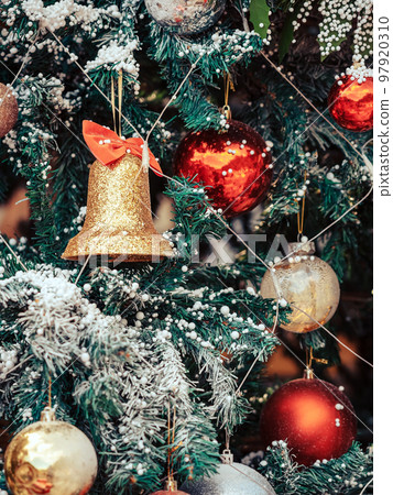 Golden jingle bells christmas ornament hanging on artificial pine tree. Stylish christmas decorations. Christmas and New Year display for celebration,carnival,festival design concept. Selective focus. 97920310