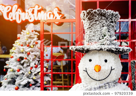 Beautiful decorative artificial snowman decoration at the entrance to a small housing community. Snowman standing in front of the public park on the Christmas holiday. Christmas and New Year Concept. Beautiful decorative artificial snowman decoration at the entrance to a small housing community. Snowman standing in front of the public park on the Christmas holiday. Christmas and New Year Concept. 97920339