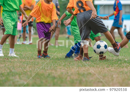 Football soccer children training class. Kindergarten school kids playing football in a field. Group of boys running and kicking soccer on sports grass pitch. Children in sportswear on football match. Football soccer children training class. Kindergarten school kids playing football in a field. Group of boys running and kicking soccer on sports grass pitch. Children in sportswear on football match. 97920538