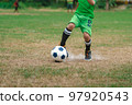 Football soccer children training class. Kindergarten school kids playing football in a field. Group of boys running and kicking soccer on sports grass pitch. Children in sportswear on football match. 97920543