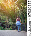 Asian woman enjoy playing and riding modern extreme stunt kick scooter without using any safety gear in home. Active sport lifestyle of young female in nature. Happy woman ride scooter without helmet. 97920557