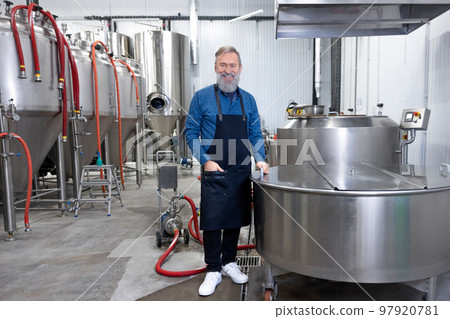 Factory worker standing near the tank with beer 97920781