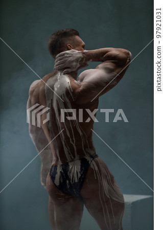 Back view of shirtless athletic strong man at studio Back view of shirtless athletic strong man at studio 97921031