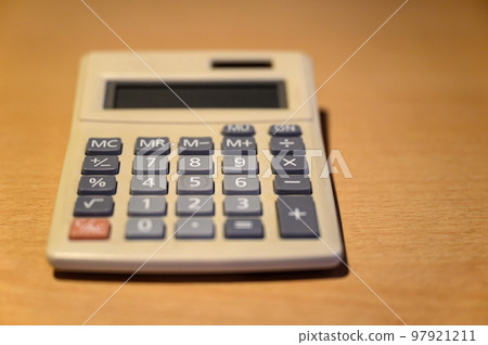 Electronic calculator on a desk. Basic solar calculator representing old technology. Focus on number 8 with shallow depth of field. No logo or branding. 97921211