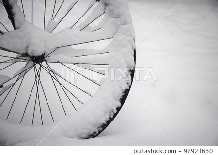 Wheel of a parked bicycle in winter. 97921630
